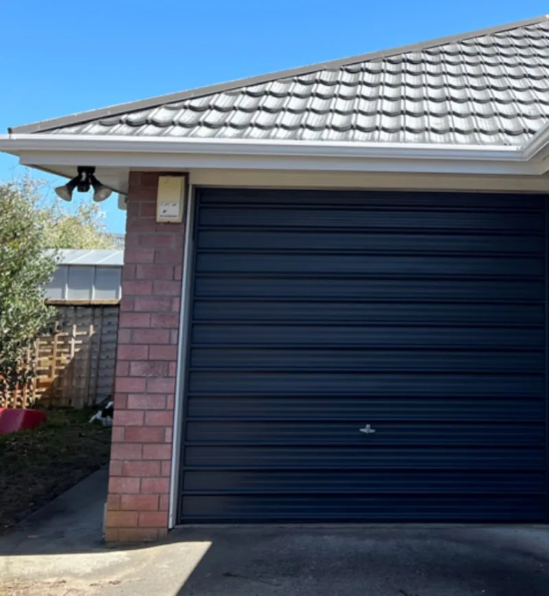 The same garage roller door with an even dark finish.