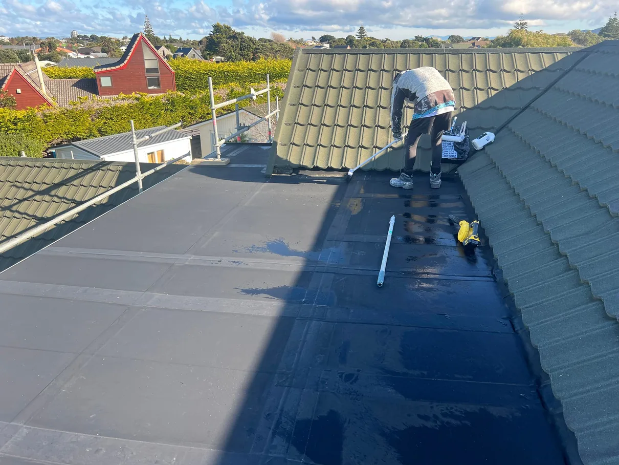 Painter working on a roof surface.